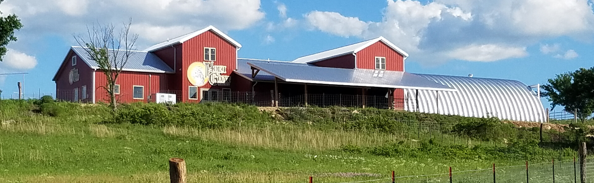 Photo of Holy Goat Creamery up on a hill surrounded by grass